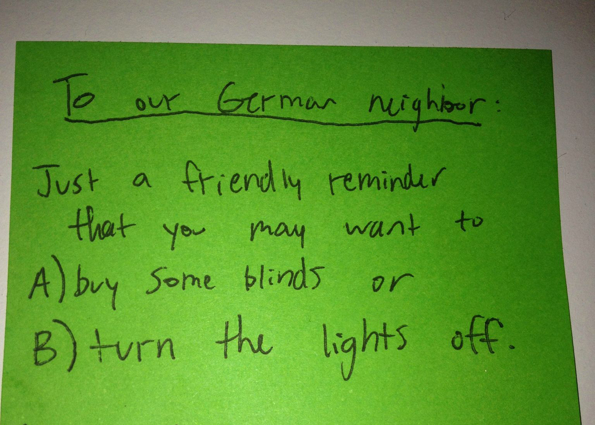 A note asks a German neighbor to shut the blinds or turn off the lights.