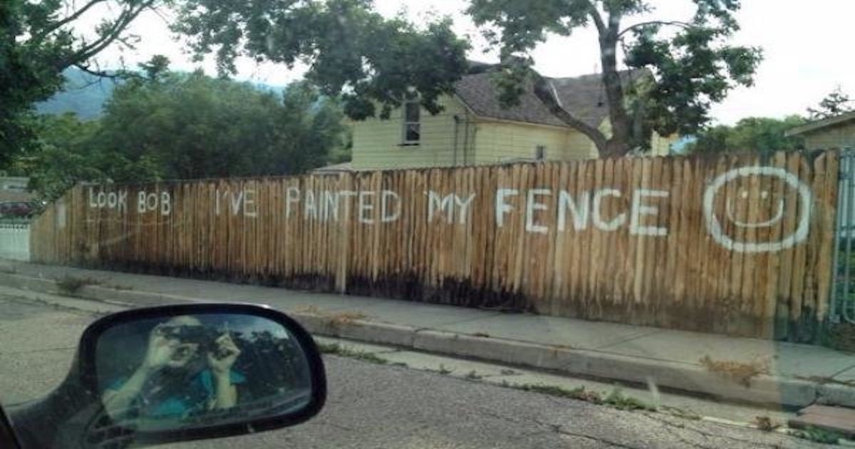 An old fence is painted with the words