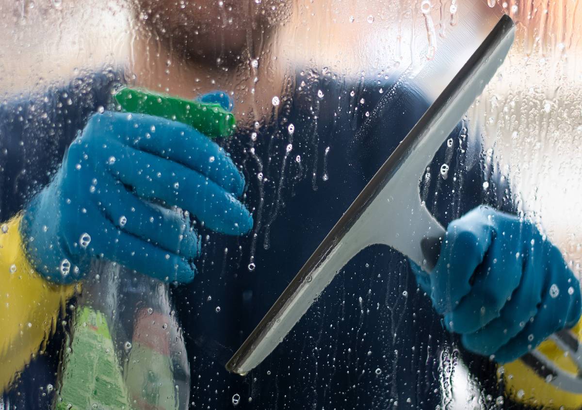 someone washing window from outside with squeegee