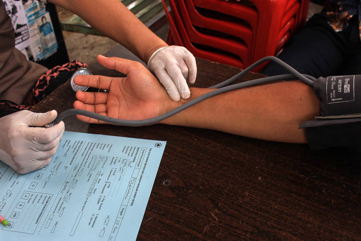 A doctor checks a patient's blood pressure and heartrate.